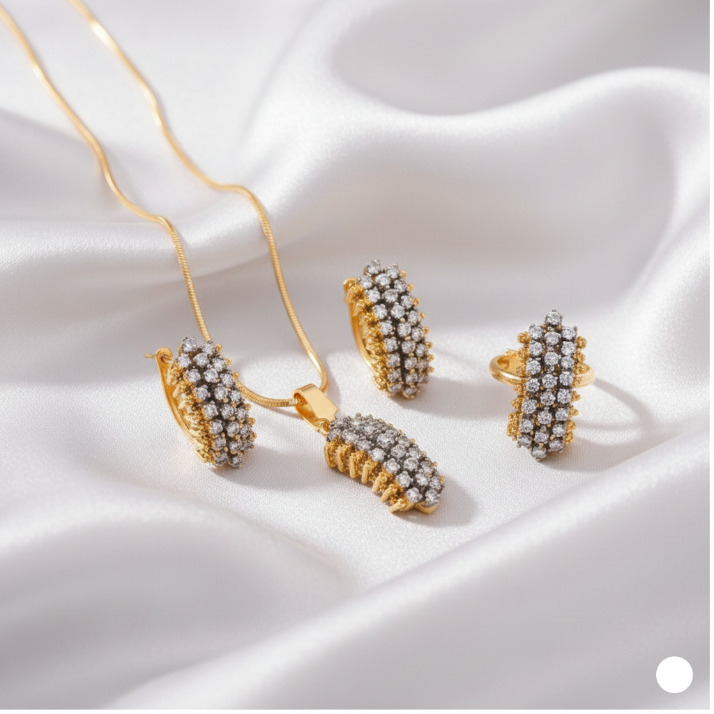 Gold jewelry set with necklace, earrings, and ring on a white fabric background